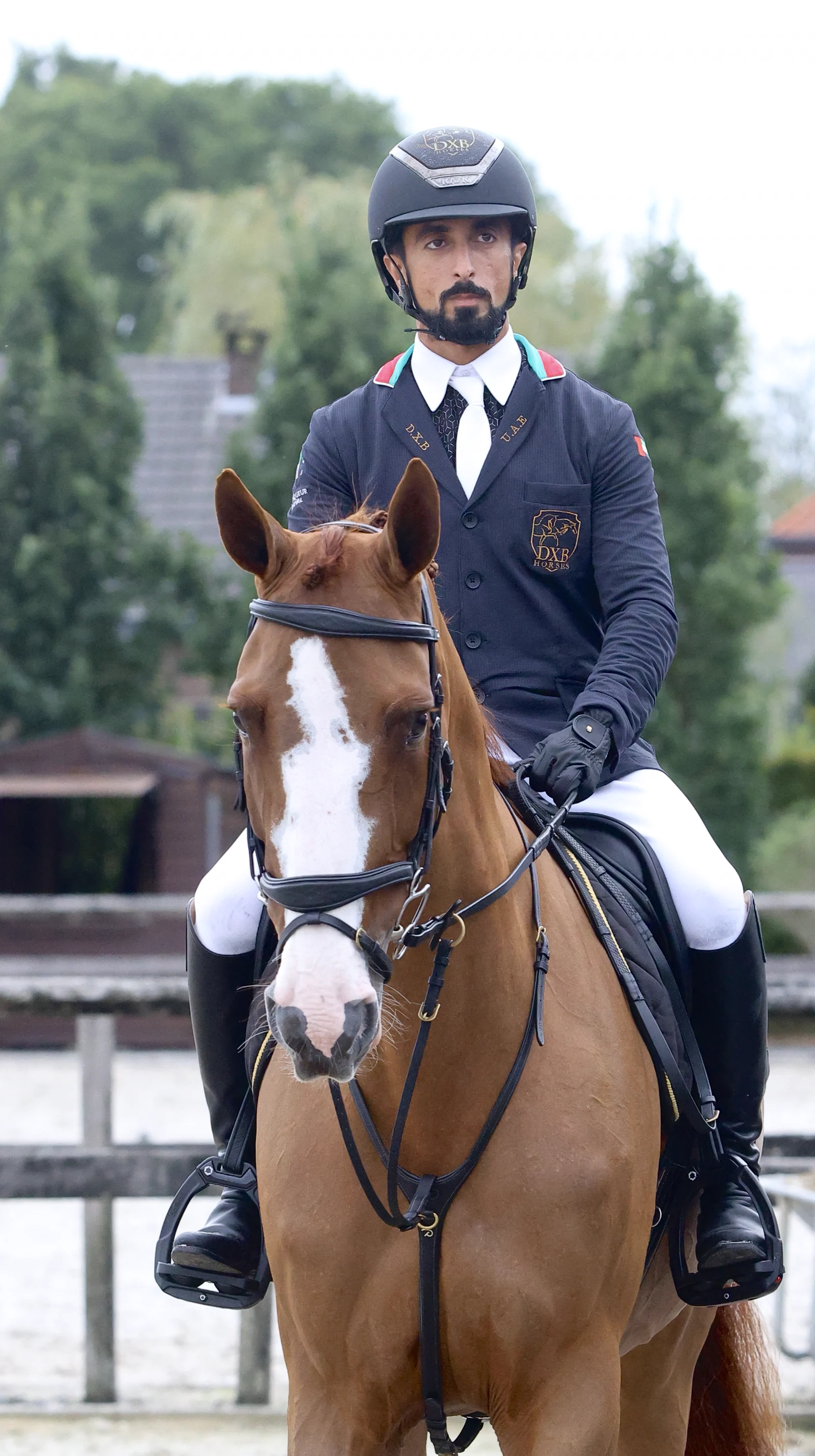 Shk. Rashid bin Ahmed Al Maktoum wearing a navy competition jacket with UAE colour details